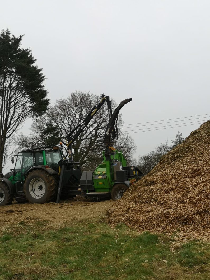 Crane fed chipper chipping wood